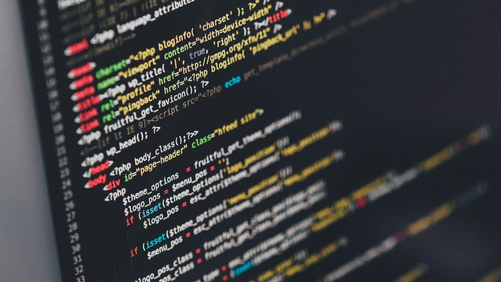 Close-up of source code displayed on a dark monitor