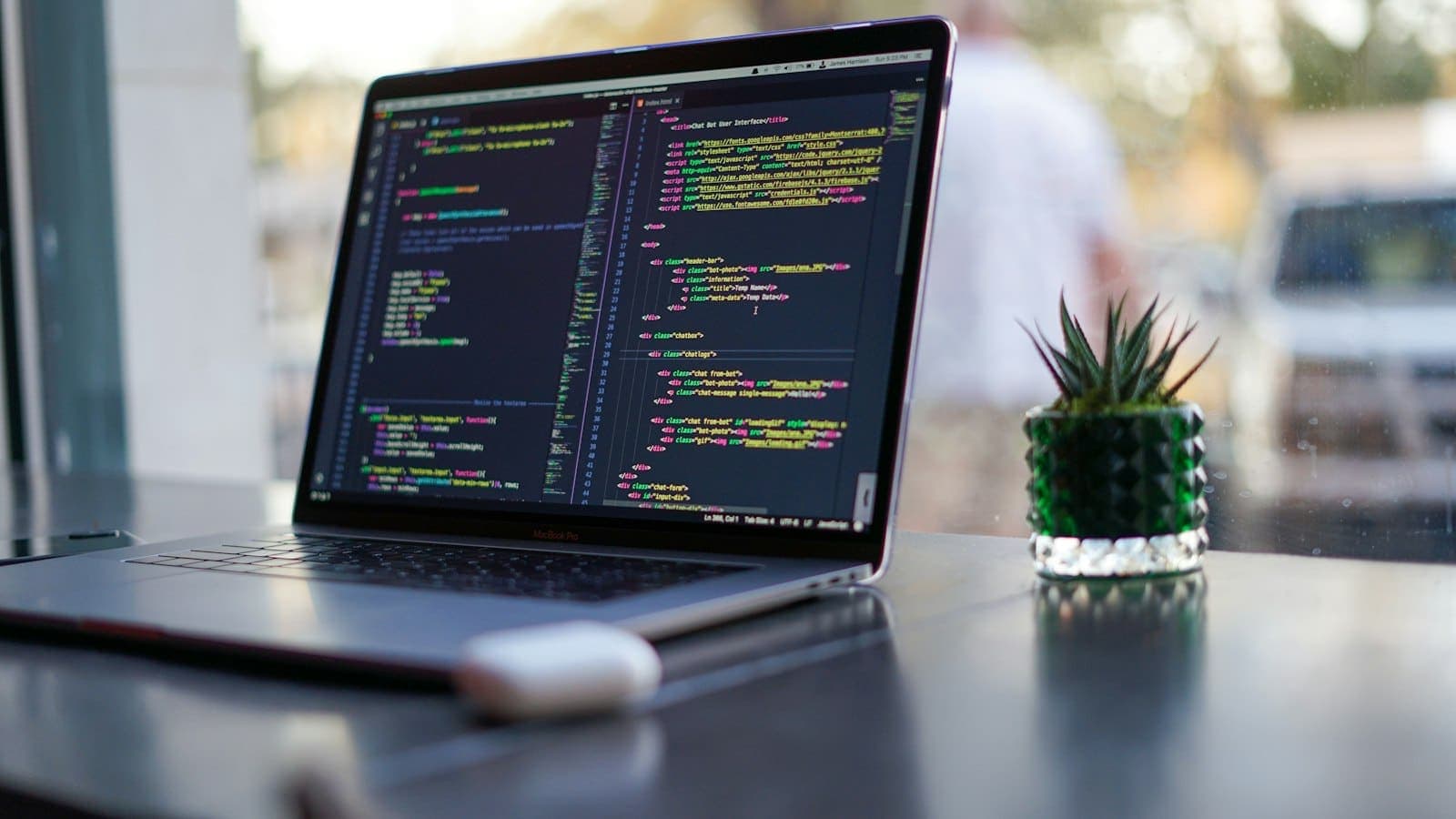 A laptop on a desk showing code in an editor